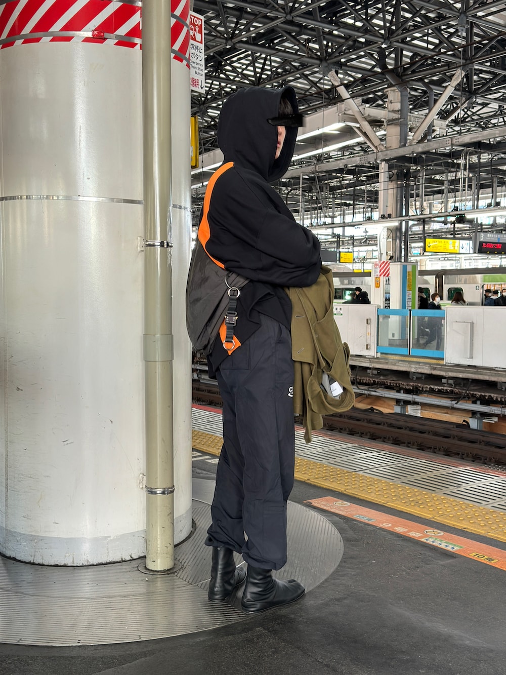 ブラック系のショルダーバッグ、ブラック系のその他パンツ、ブラック系のブーツを着用したメンズの冬コーディネートの3枚目の写真
