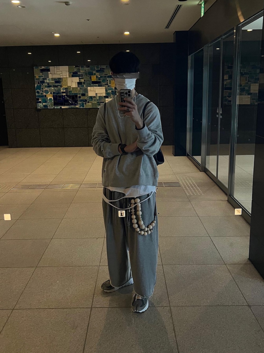 グレー系のスニーカー、グレー系のスウェットパンツ、ホワイト系のTシャツ/カットソーを着用したメンズの冬コーディネートの2枚目の写真