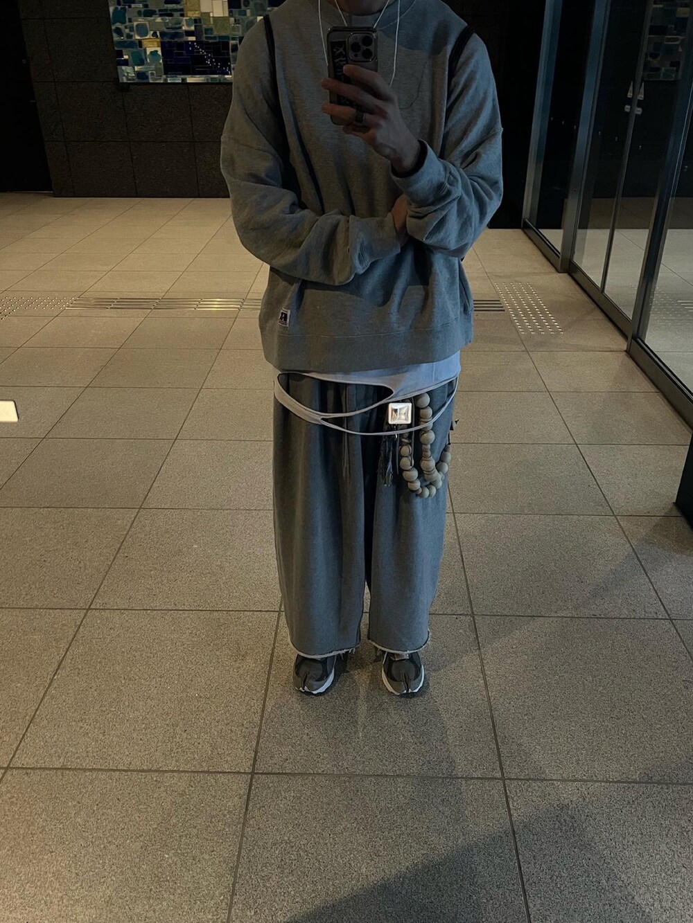 グレー系のスニーカー、グレー系のスウェットパンツ、ホワイト系のTシャツ/カットソーを着用したメンズの冬コーディネートの3枚目の写真