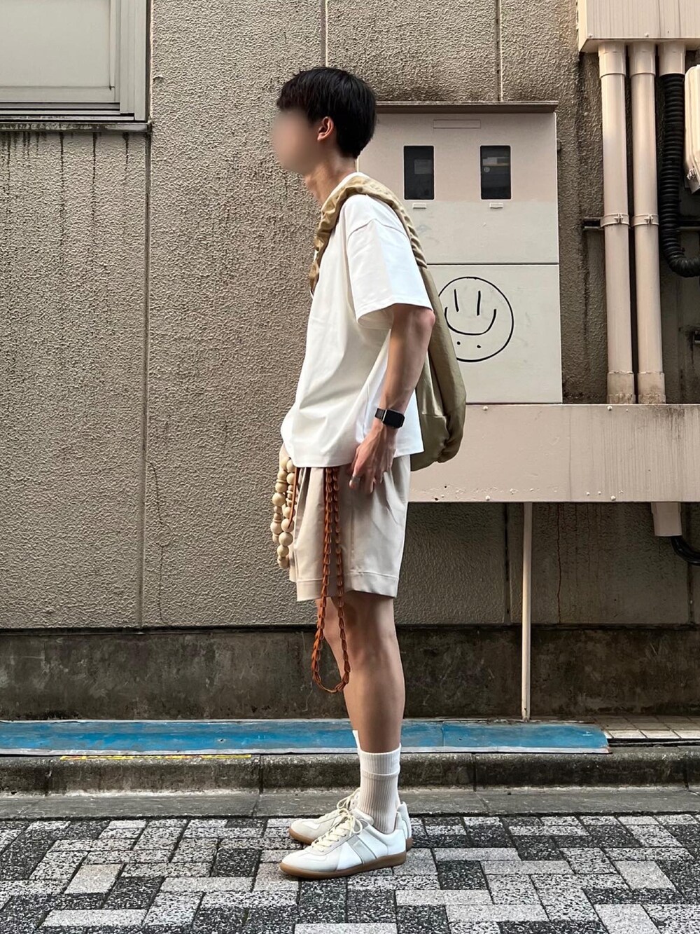 ホワイト系のスニーカー、ベージュ系のその他パンツ、ベージュ系のショルダーバッグを着用したメンズの夏コーディネートの3枚目の写真