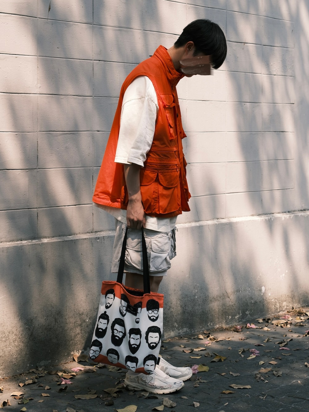 ベージュ系のTシャツ/カットソー、オレンジ系のナイロンジャケット、ホワイト系のその他パンツを着用したメンズの秋コーディネートの3枚目の写真