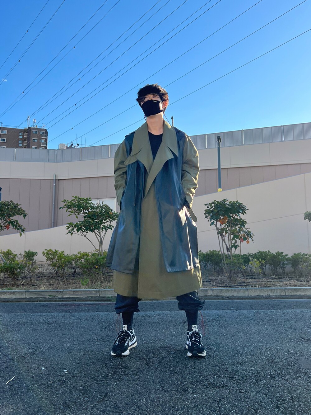 ブラック系のスニーカー、ブラック系のパンツ、ブラック系のベストを着用したメンズの冬コーディネートの2枚目の写真