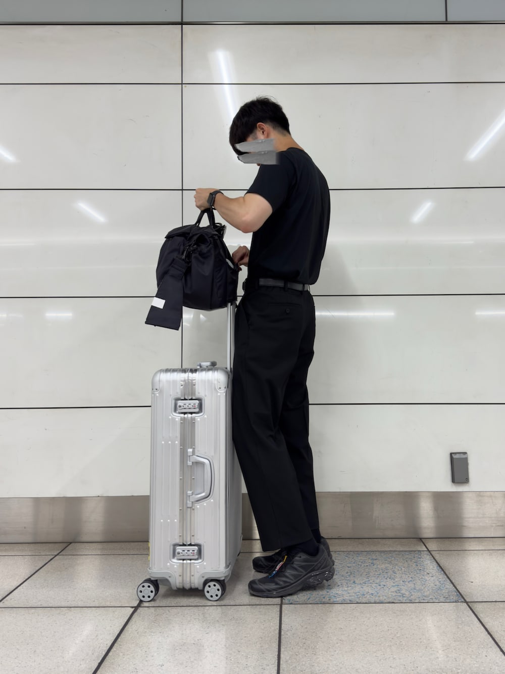 ブラック系のスニーカー、ブラック系のスラックス、シルバー系のスーツケース/キャリーバッグを着用したメンズの秋コーディネートの3枚目の写真