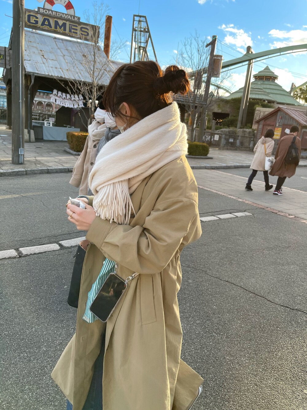 ブルー系のデニムパンツ、グリーン系のシャツ/ブラウス、ベージュ系のトレンチコートを着用したレディースの冬コーディネートの3枚目の写真