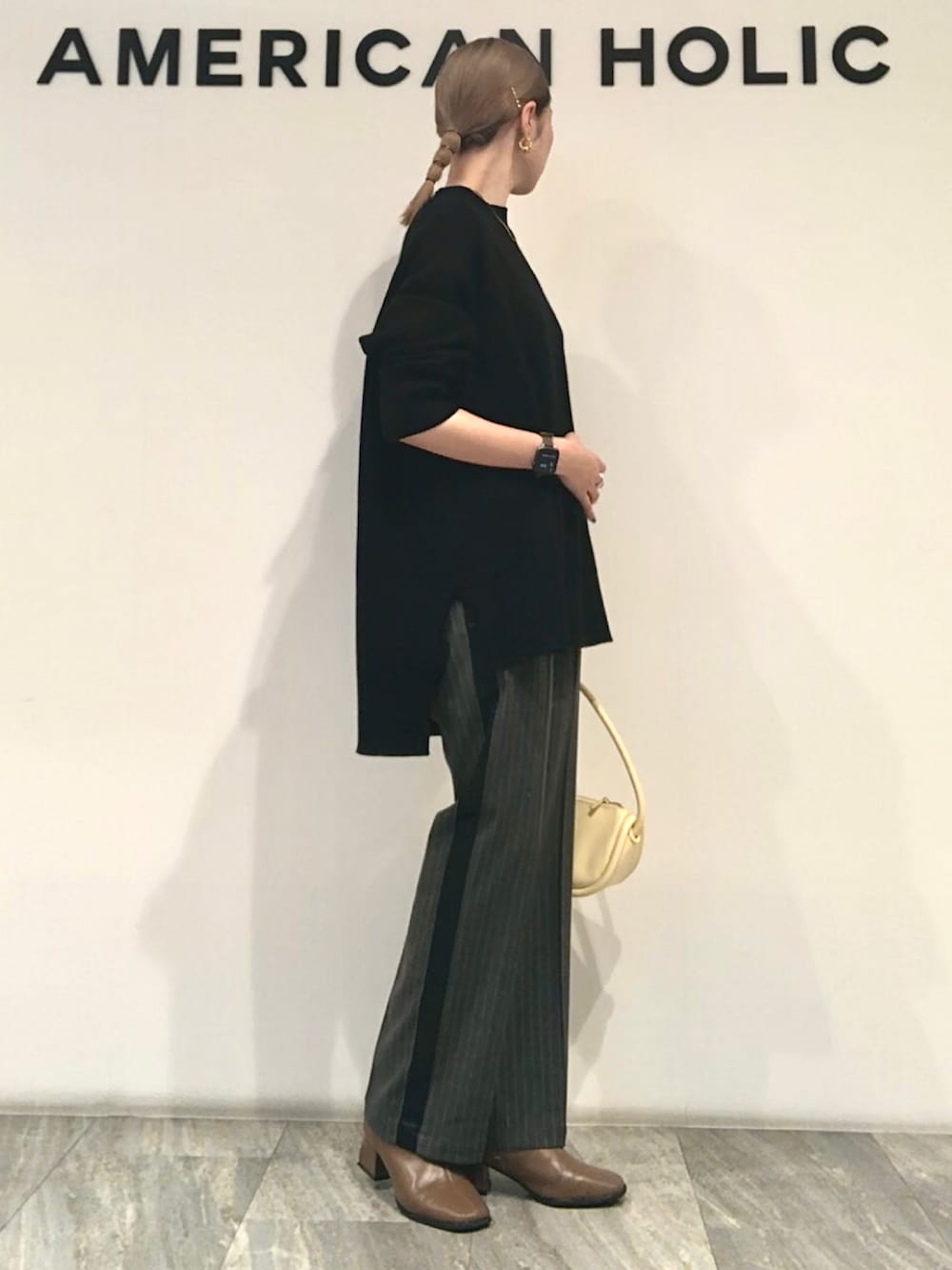 ブラック系のニット/セーター、その他のその他パンツ、イエロー系のショルダーバッグを着用したレディースの秋コーディネートの2枚目の写真