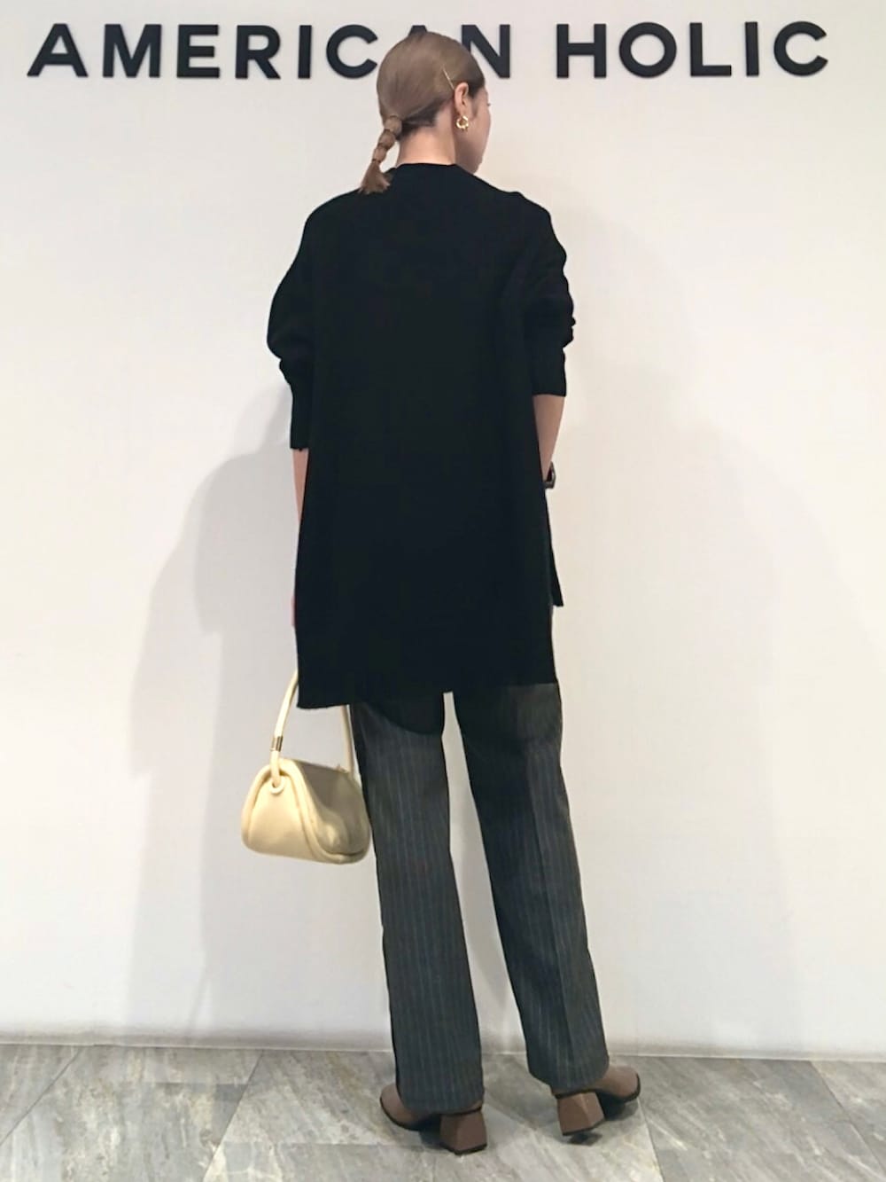 ブラック系のニット/セーター、その他のその他パンツ、イエロー系のショルダーバッグを着用したレディースの秋コーディネートの3枚目の写真