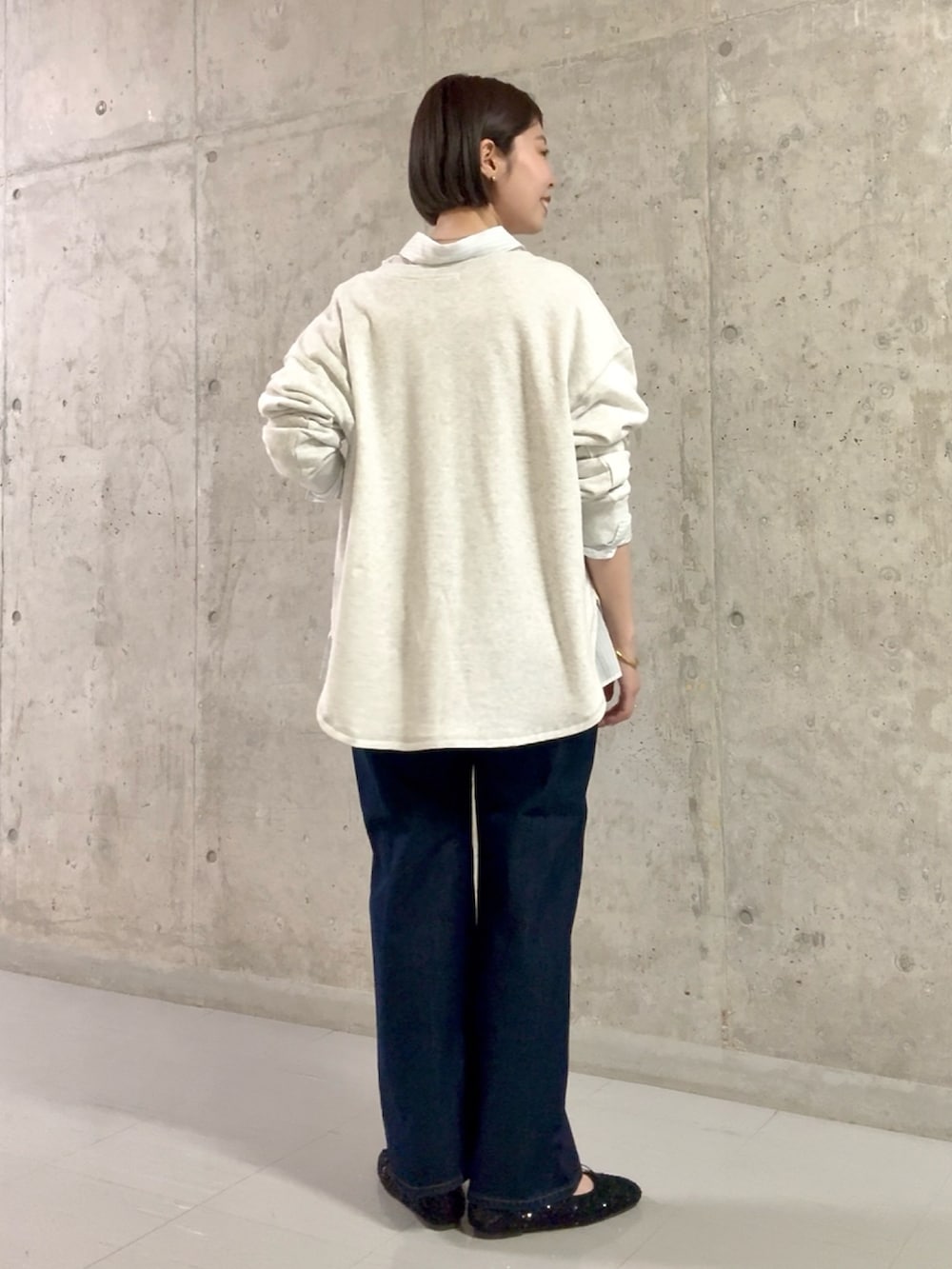 ホワイト系のシャツ/ブラウス、ブルー系のデニムパンツ、ブラック系のパンプスを着用したレディースの春コーディネートの4枚目の写真