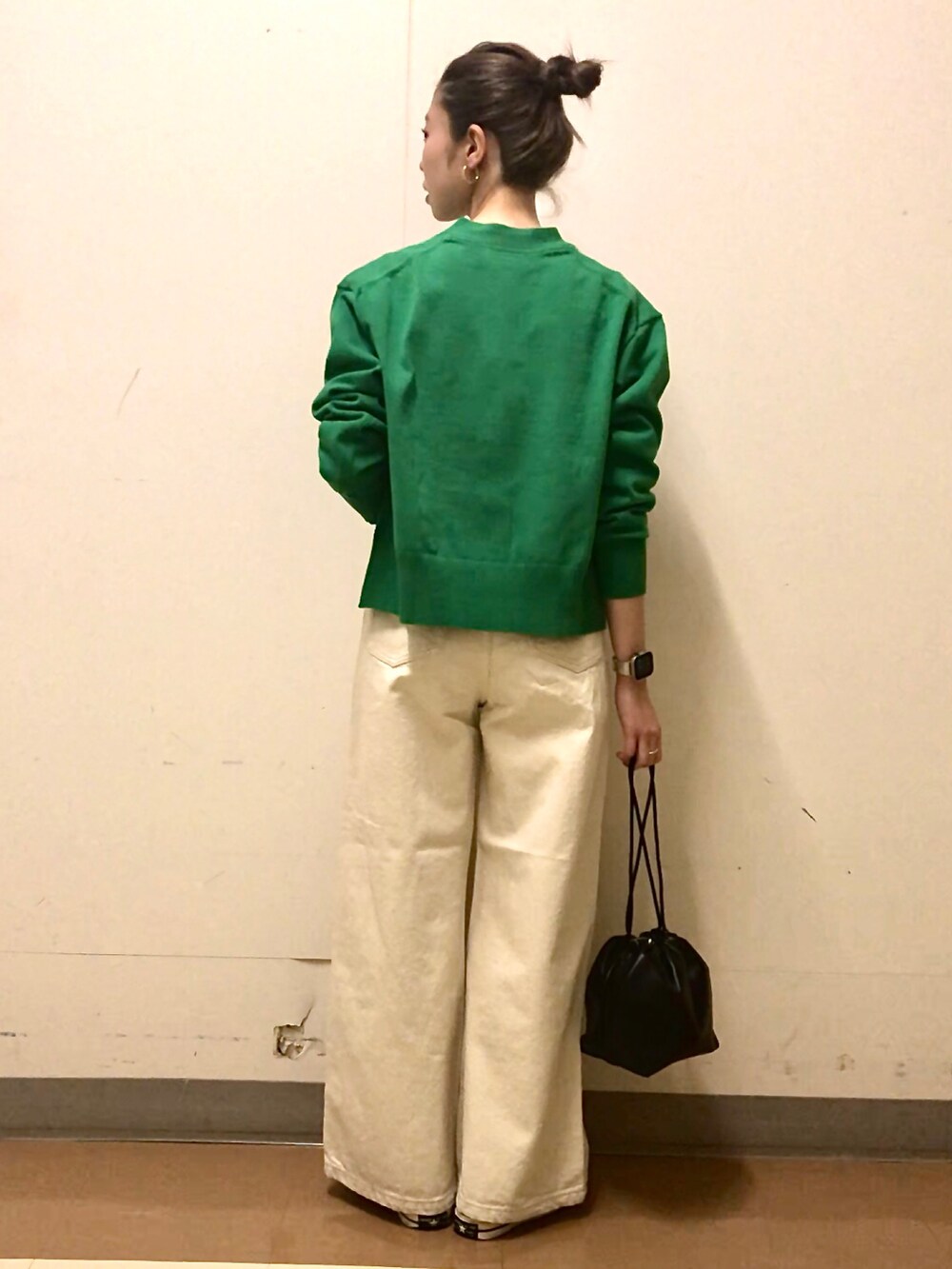 グリーン系のカーディガン/ボレロ、ホワイト系のTシャツ/カットソー、ベージュ系のデニムパンツを着用したレディースの春コーディネートの3枚目の写真