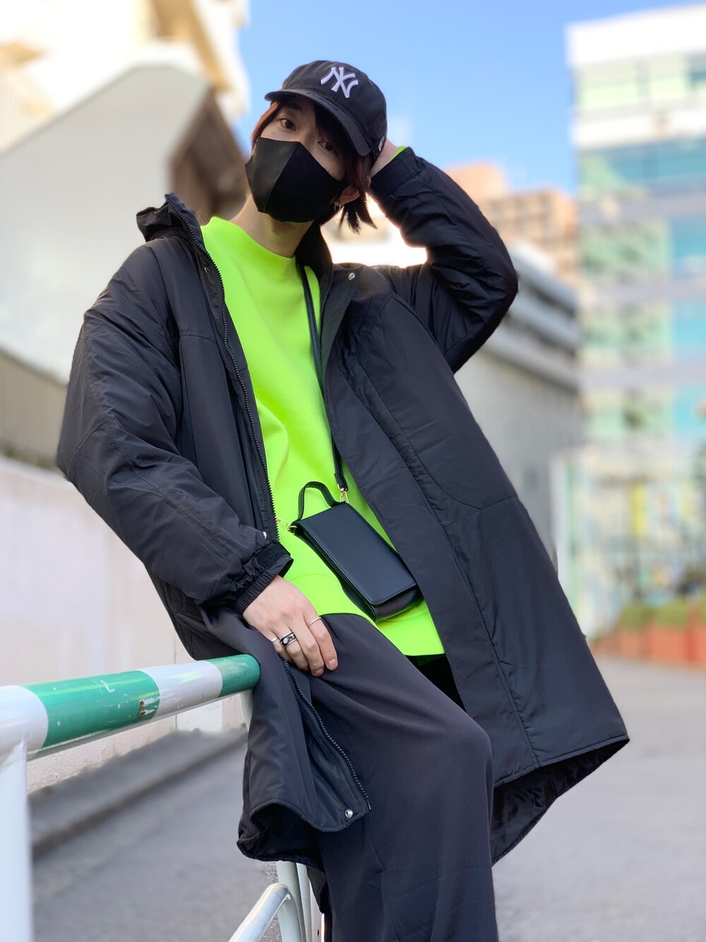 ブラック系のダウンジャケット/コート、イエロー系のスウェット、ブラック系のスマホケース/カバーを着用したメンズの冬コーディネートの2枚目の写真