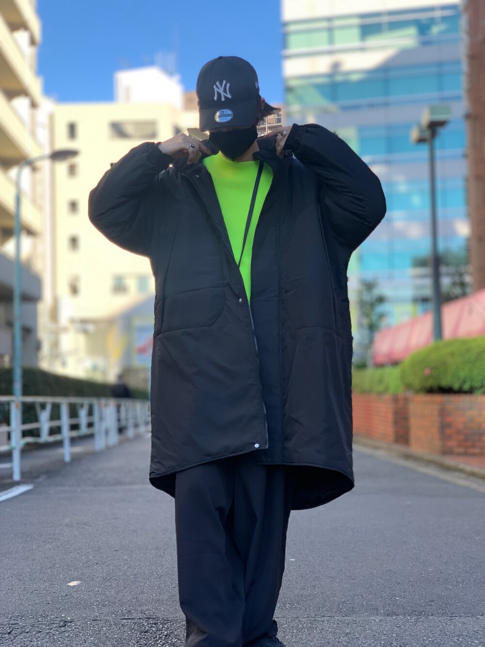 ブラック系のダウンジャケット/コート、イエロー系のスウェット、ブラック系のスマホケース/カバーを着用したメンズの冬コーディネートの3枚目の写真