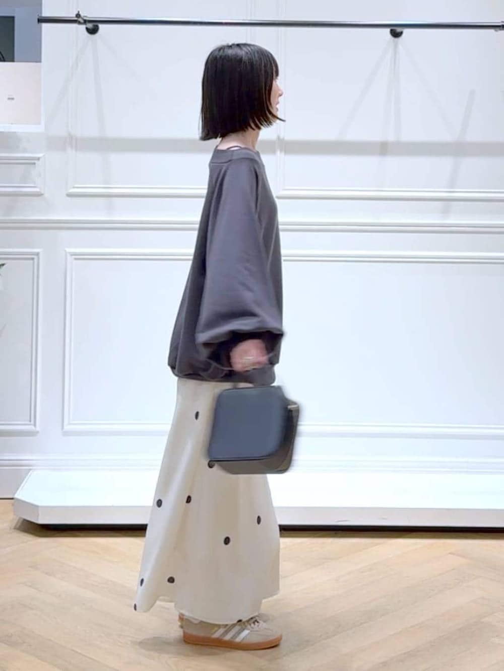 ベージュ系のスニーカー、グレー系のスウェット、ホワイト系のスカートを着用したレディースの春コーディネートの3枚目の写真