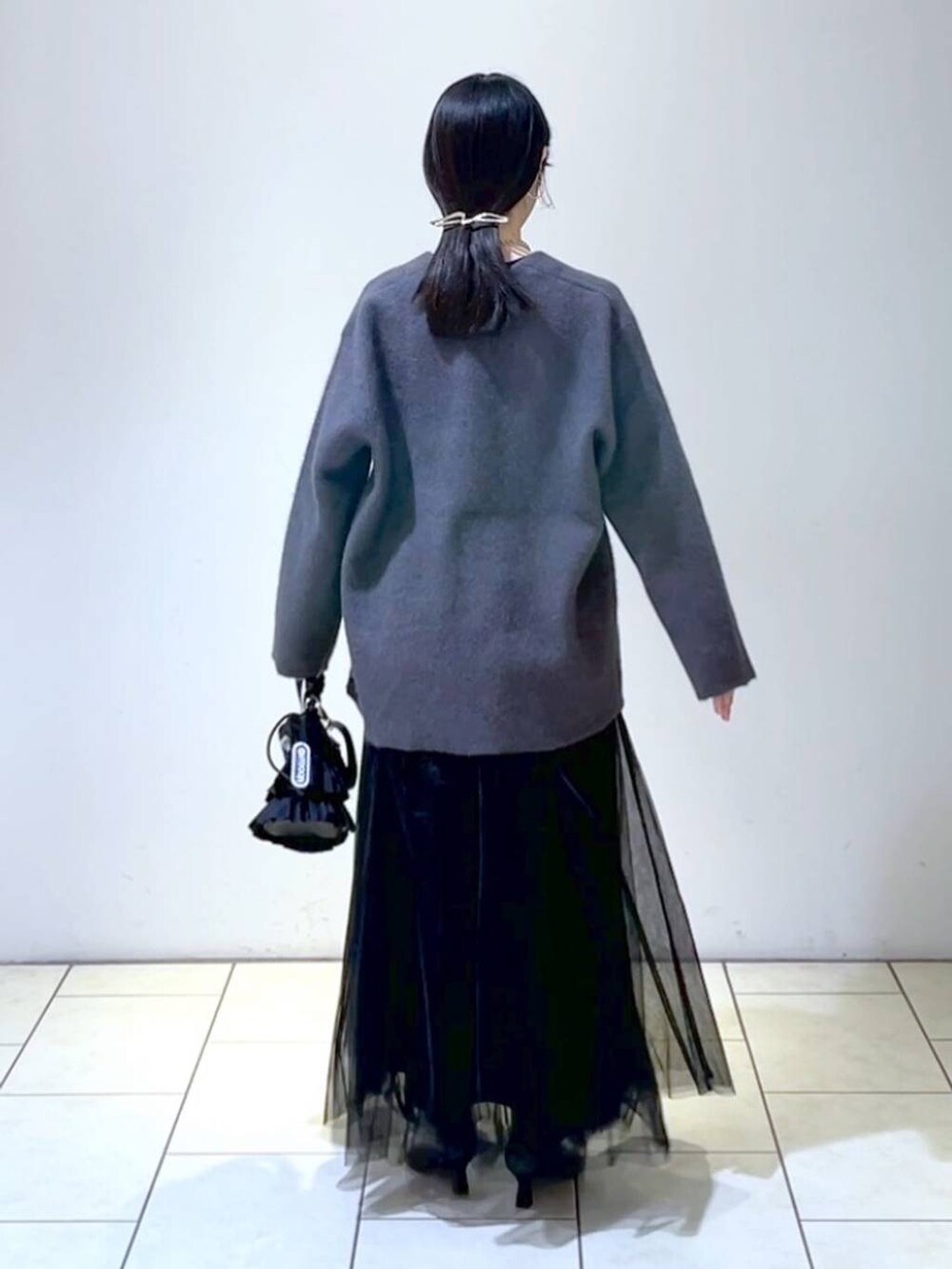 ブラック系のショルダーバッグ、グレー系のニット/セーター、ブラック系のブーツを着用したレディースの冬コーディネートの4枚目の写真