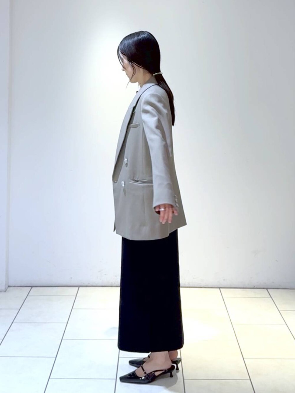 ホワイト系のワンピース、ブラック系のパンプス、グレー系のテーラードジャケットを着用したレディースの冬コーディネートの6枚目の写真