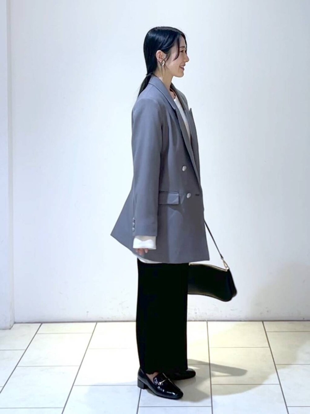 ホワイト系のシャツ/ブラウス、ブラック系のローファー、ブラック系のショルダーバッグを着用したレディースの春コーディネートの2枚目の写真