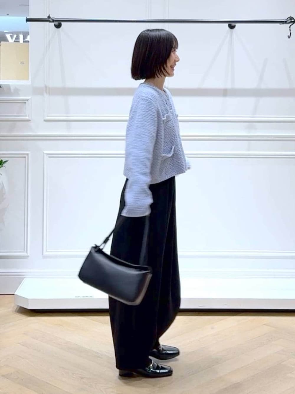 ブラック系のローファー、ブラック系のスラックス、ブルー系のカーディガン/ボレロを着用したレディースの冬コーディネートの3枚目の写真