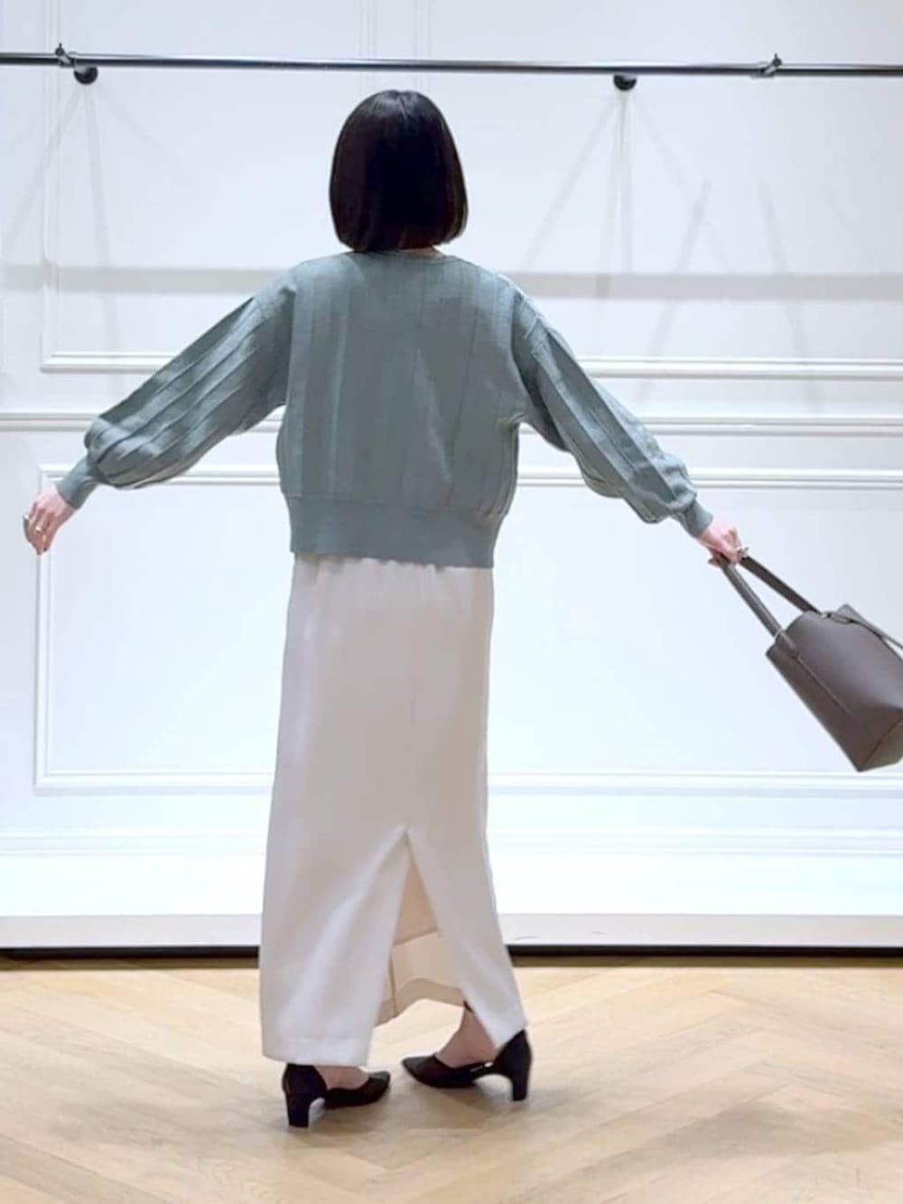 グリーン系のカーディガン/ボレロ、ブラック系のパンプス、ブラウン系のショルダーバッグを着用したレディースの春コーディネートの4枚目の写真