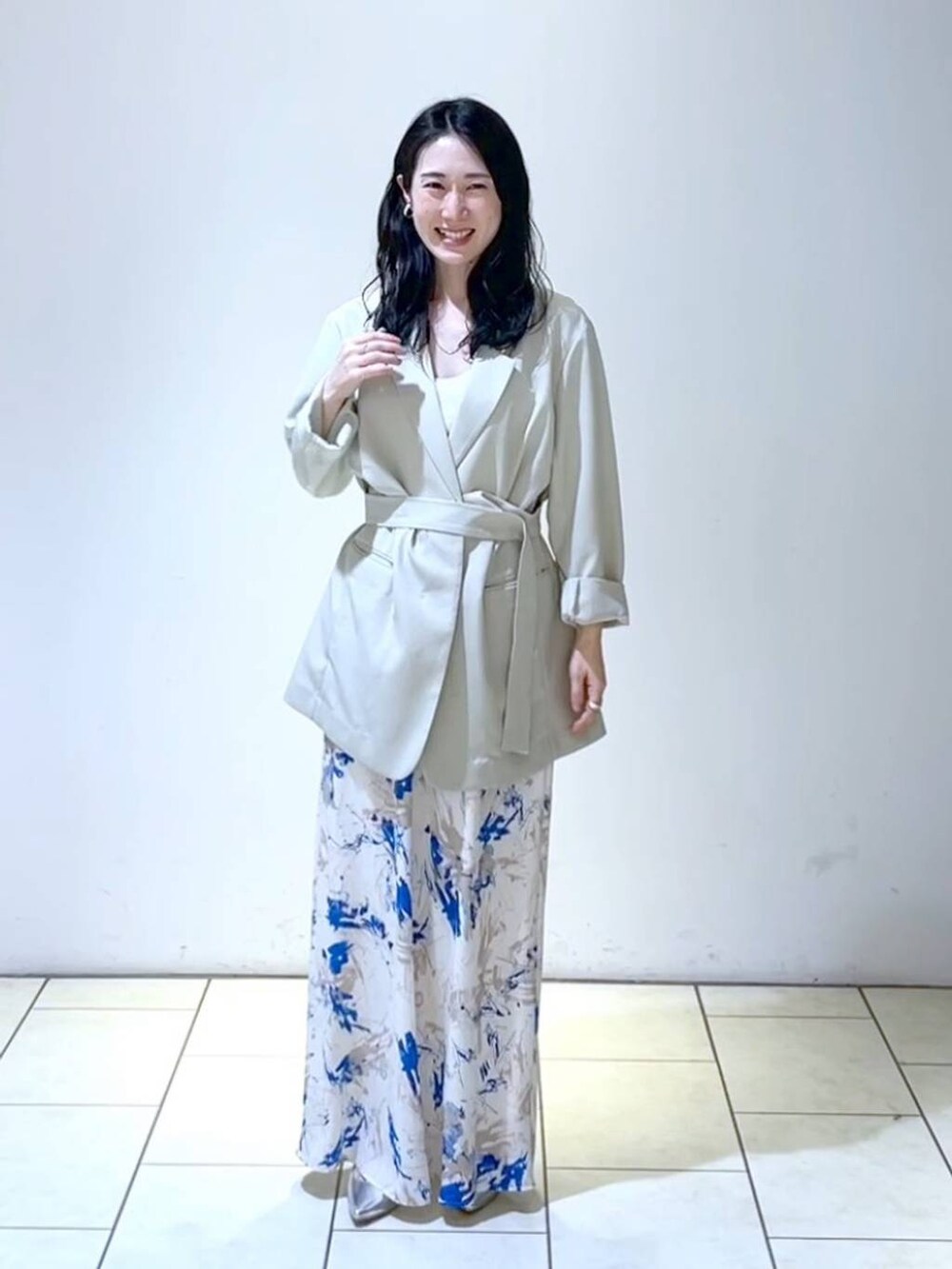 シルバー系のサンダル、ブルー系のスカート、ベージュ系のテーラードジャケットを着用したレディースの春コーディネートの6枚目の写真