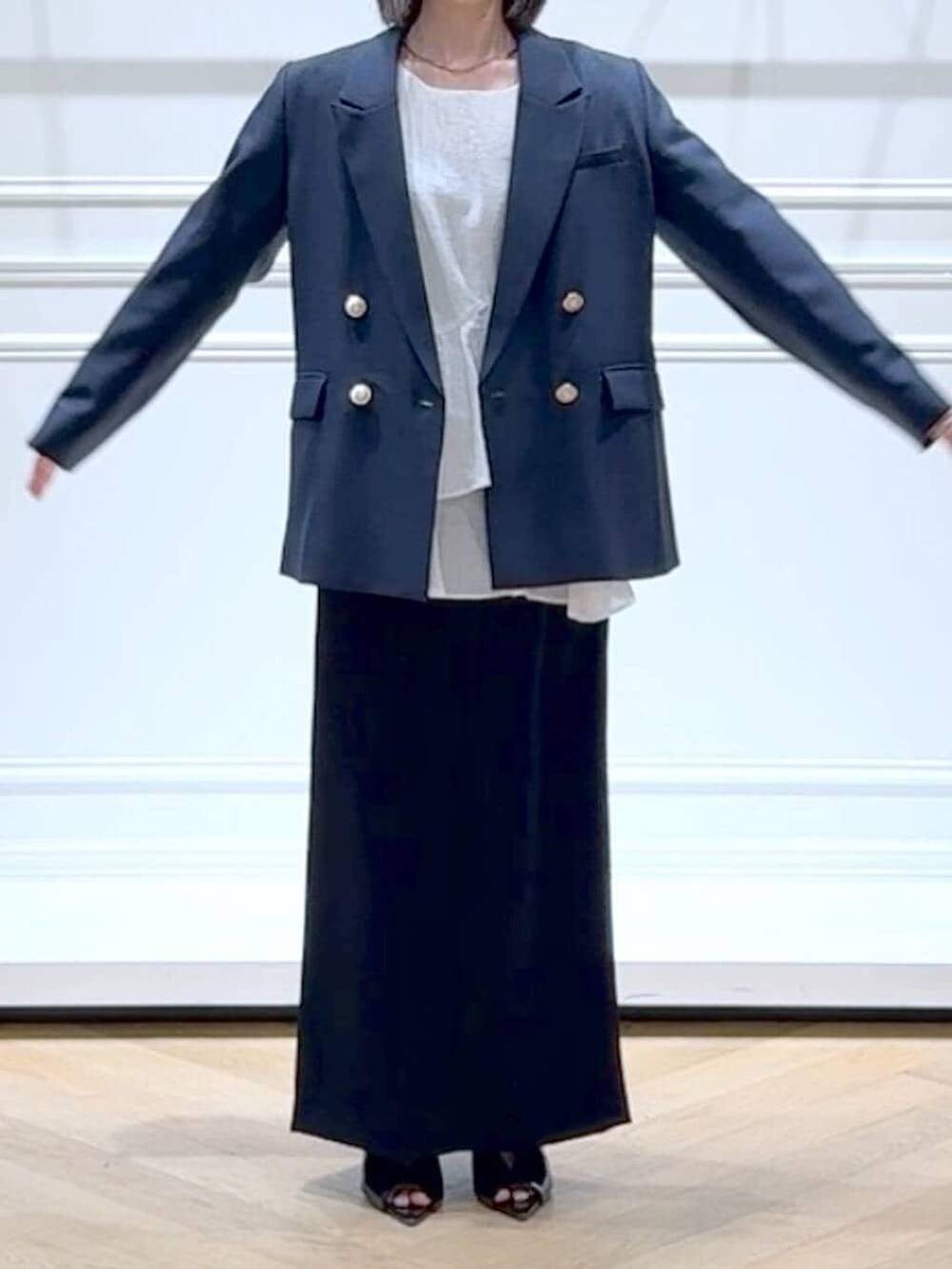 ブルー系のテーラードジャケット、ホワイト系のシャツ/ブラウス、ブラック系のサンダルを着用したレディースの春コーディネートの2枚目の写真