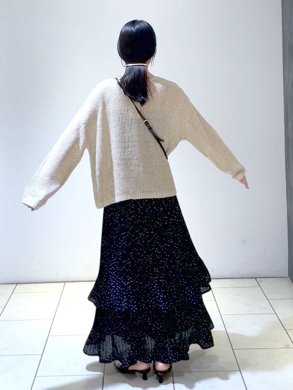 ベージュ系のニット/セーター、ブラック系のパンプス、グレー系のスカートを着用したレディースの秋コーディネートの4枚目の写真