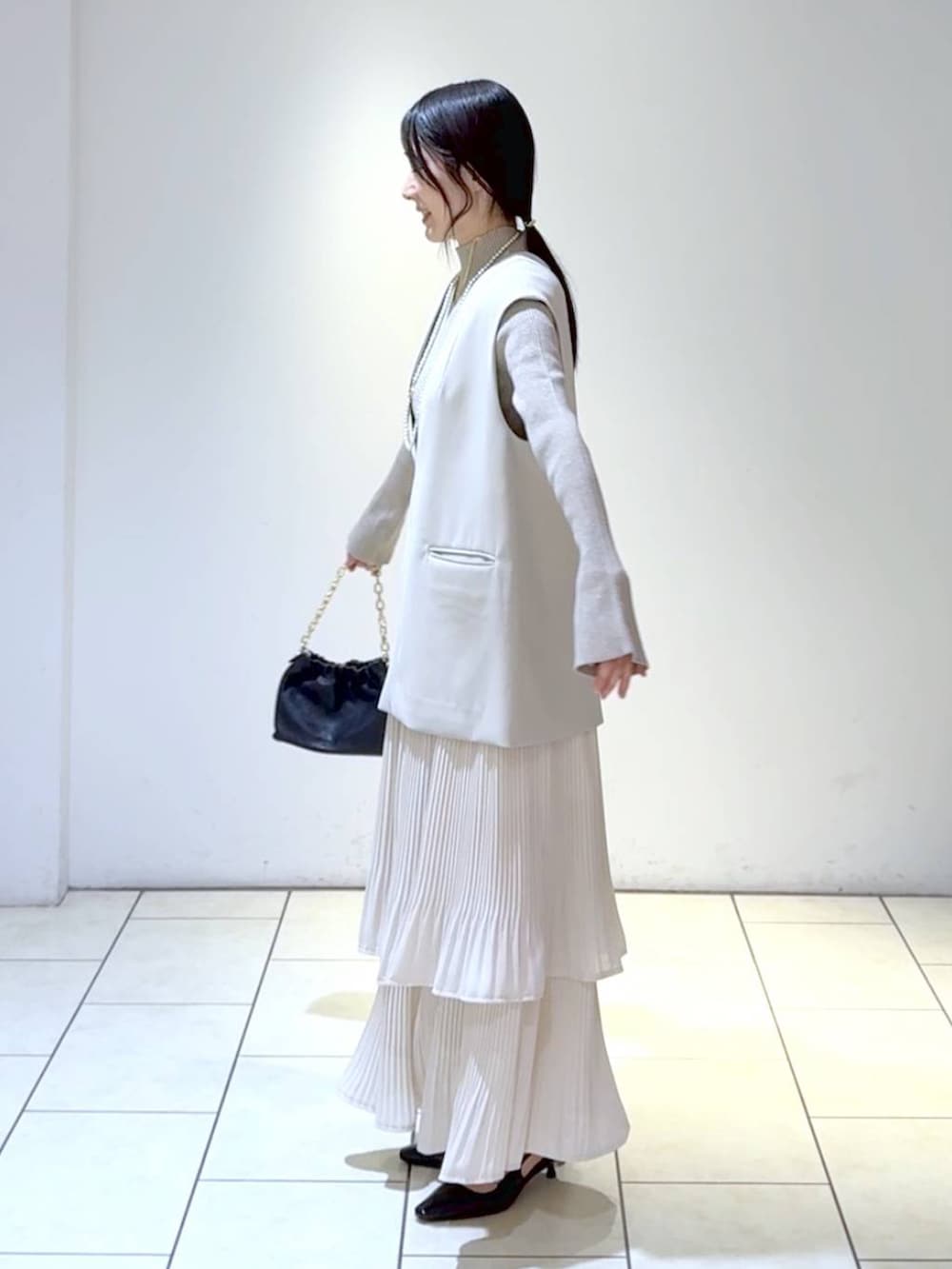 ホワイト系のスカート、ベージュ系のスーツセット、ホワイト系のニット/セーターを着用したレディースの冬コーディネートの5枚目の写真