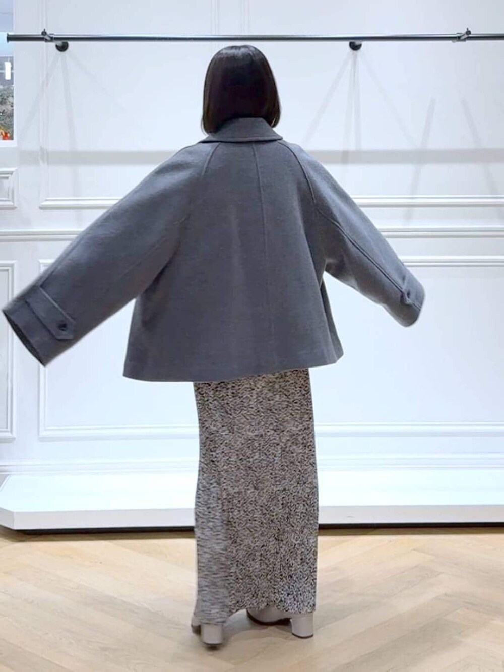 ベージュ系のブーツ、ホワイト系のニット/セーター、ベージュ系のスカートを着用したレディースの冬コーディネートの4枚目の写真