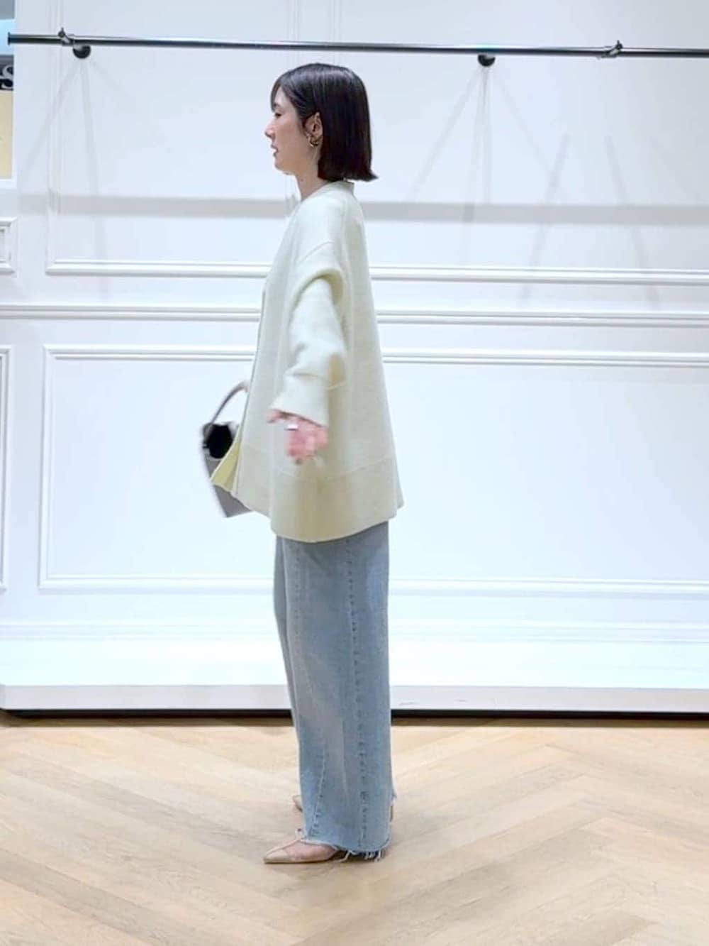 イエロー系のカーディガン/ボレロ、ブルー系のデニムパンツ、ブラウン系のショルダーバッグを着用したレディースの春コーディネートの4枚目の写真