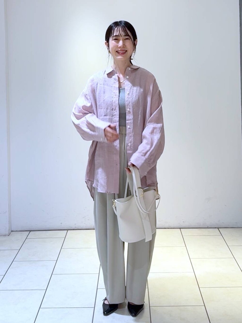 グレー系のタンクトップ、ホワイト系のショルダーバッグ、ブラック系のパンプスを着用したレディースの春コーディネートの6枚目の写真