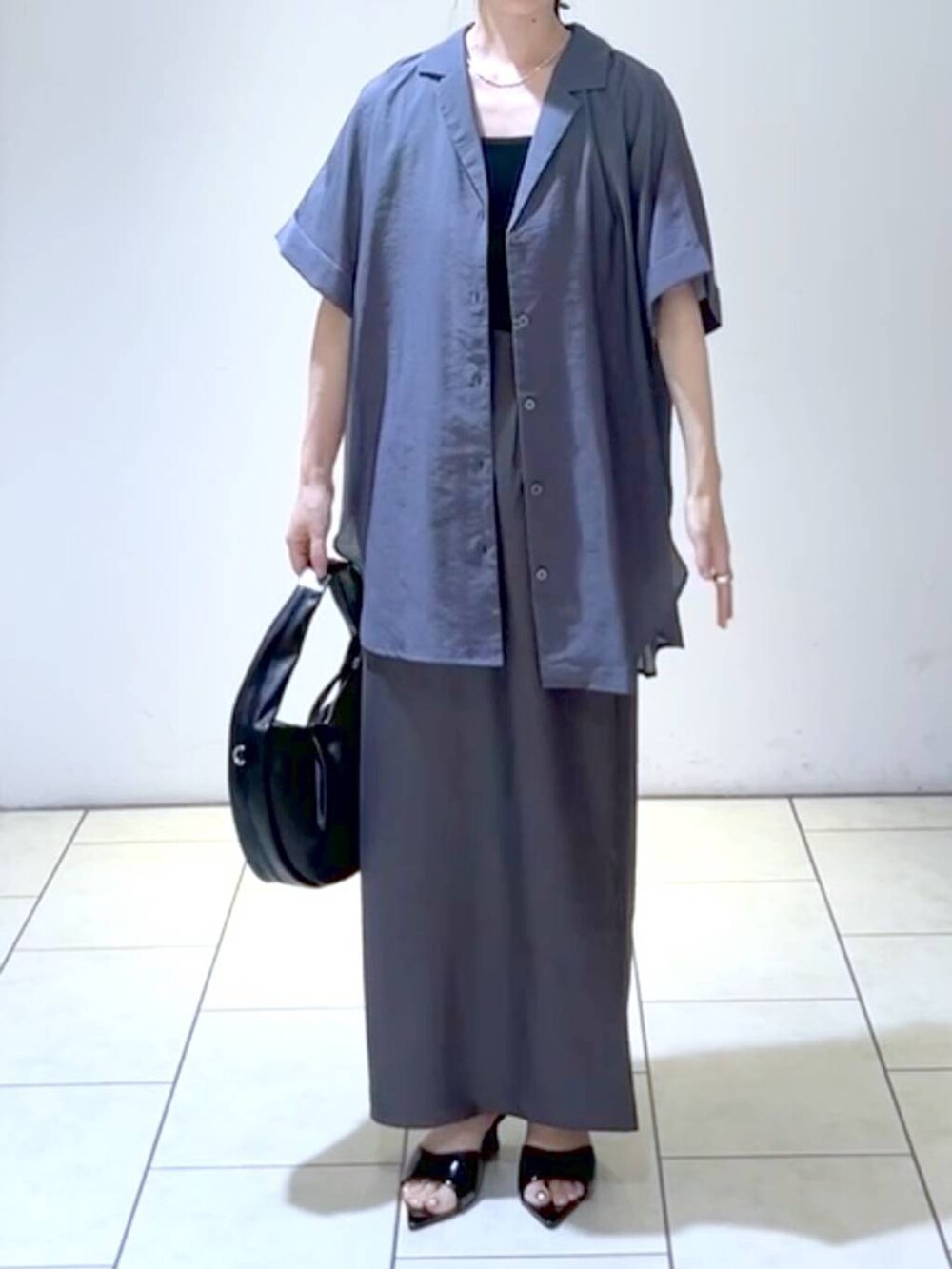 ブラック系のサンダル、ブラック系のハンドバッグ、ブラック系のタンクトップを着用したレディースの夏コーディネートの2枚目の写真