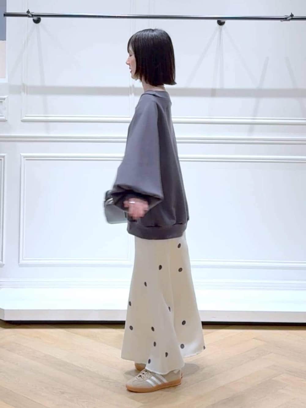 ベージュ系のスニーカー、グレー系のスウェット、ホワイト系のスカートを着用したレディースの春コーディネートの5枚目の写真