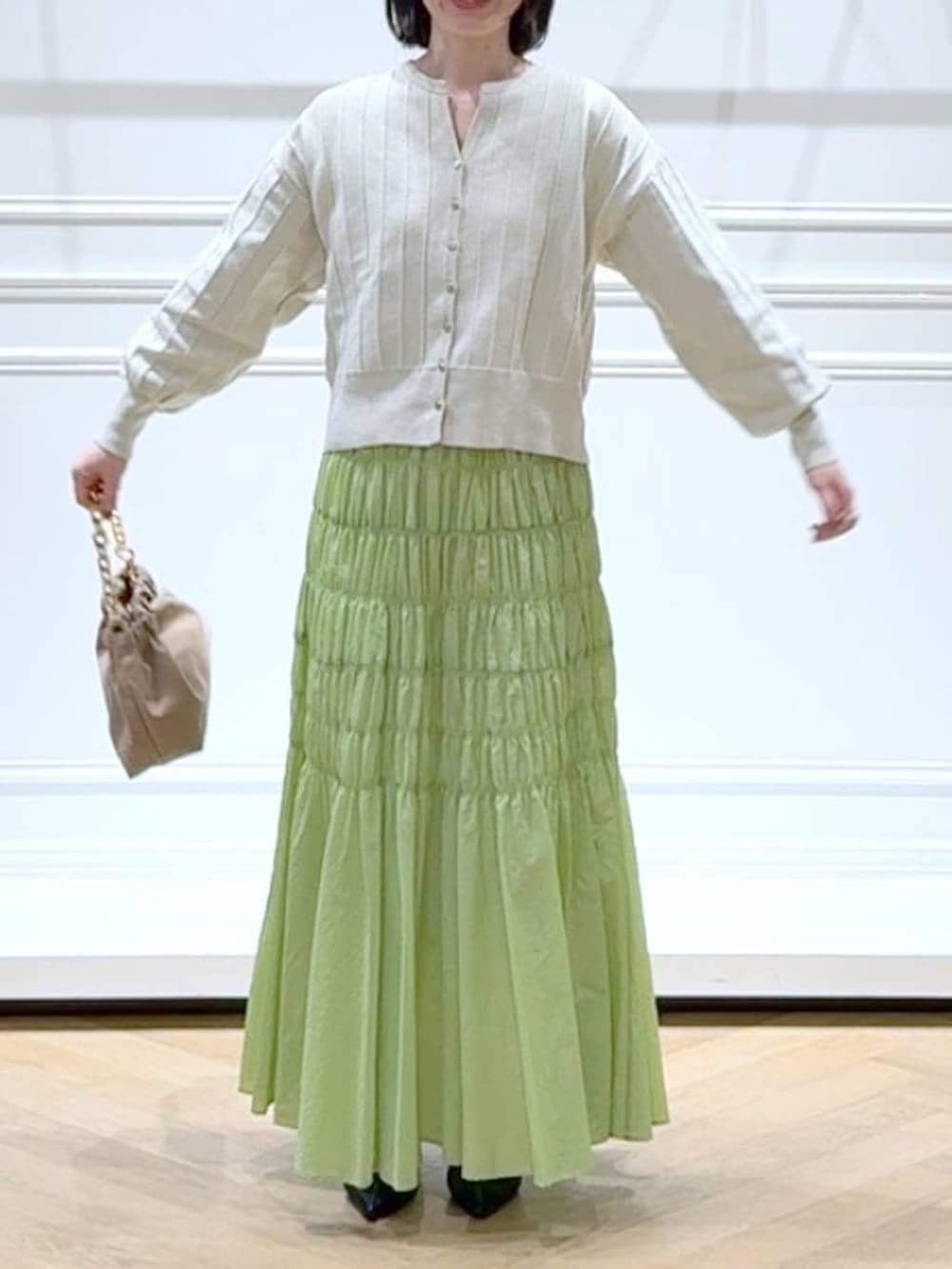 ホワイト系のカーディガン/ボレロ、ベージュ系のショルダーバッグ、ブラック系のパンプスを着用したレディースの春コーディネートの2枚目の写真