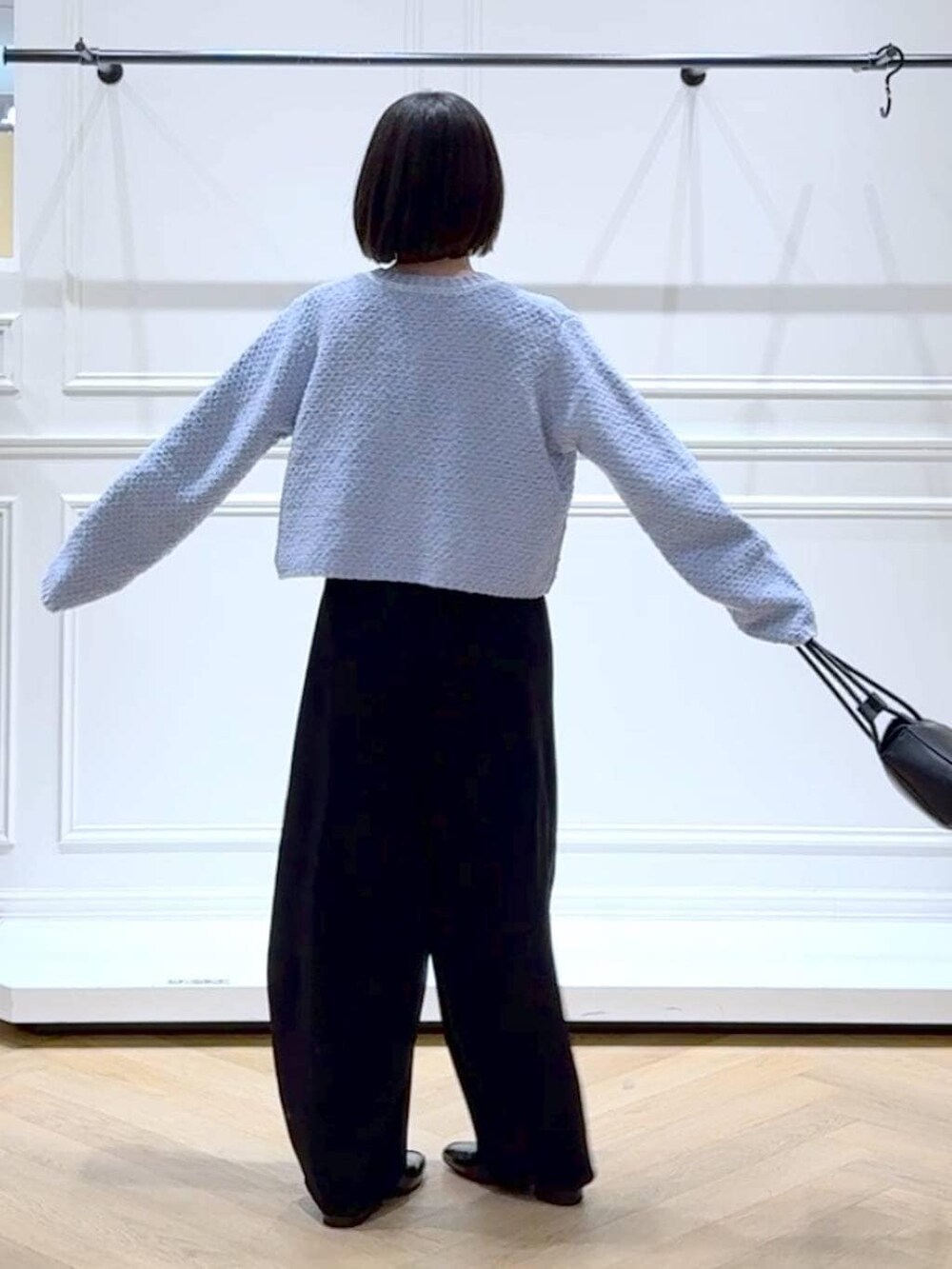 ブラック系のローファー、ブラック系のスラックス、ブルー系のカーディガン/ボレロを着用したレディースの冬コーディネートの4枚目の写真