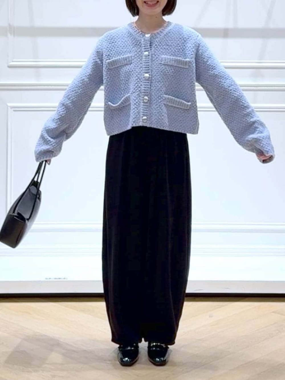 ブラック系のローファー、ブラック系のスラックス、ブルー系のカーディガン/ボレロを着用したレディースの冬コーディネートの2枚目の写真