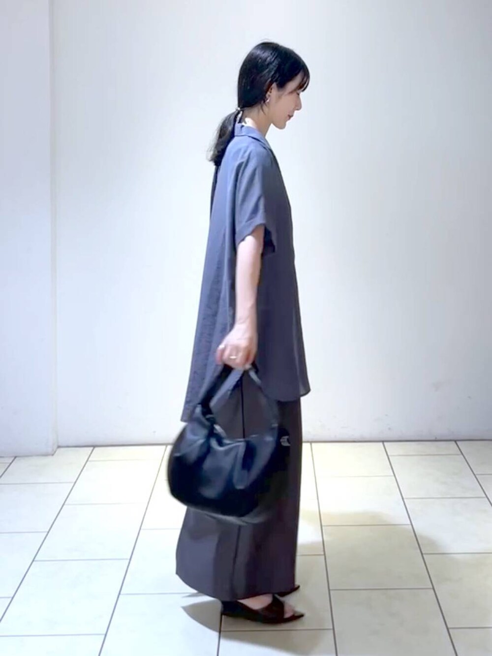 ブラック系のサンダル、ブラック系のハンドバッグ、ブラック系のタンクトップを着用したレディースの夏コーディネートの3枚目の写真