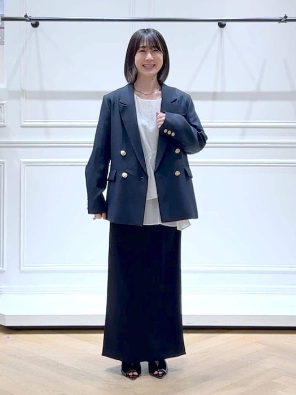 ブルー系のテーラードジャケット、ホワイト系のシャツ/ブラウス、ブラック系のサンダルを着用したレディースの春コーディネートの6枚目の写真