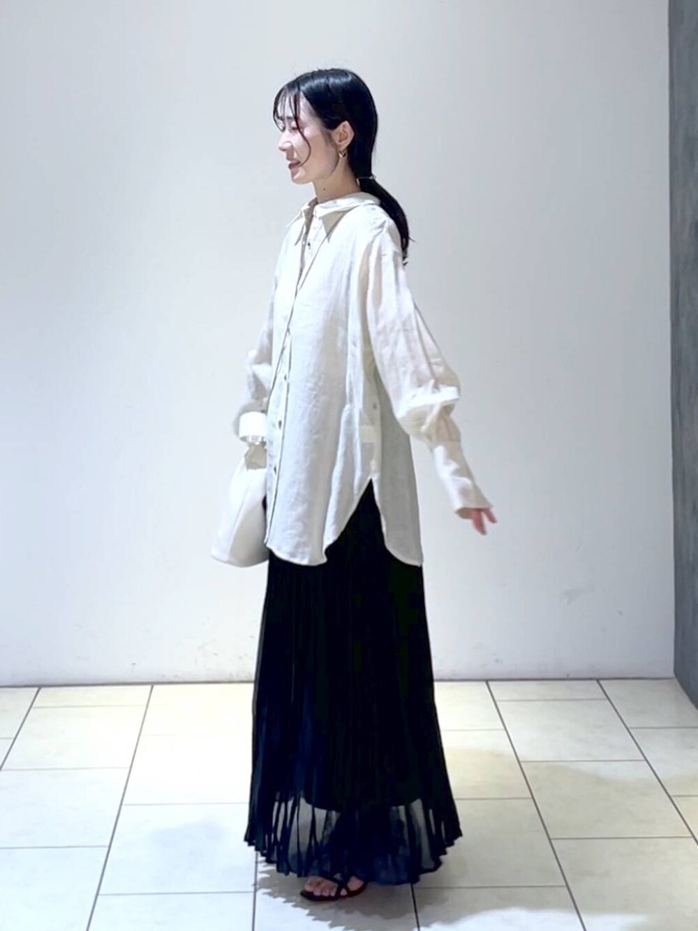 ベージュ系のシャツ/ブラウス、ブラック系のスカート、ホワイト系のショルダーバッグを着用したレディースの夏コーディネートの5枚目の写真