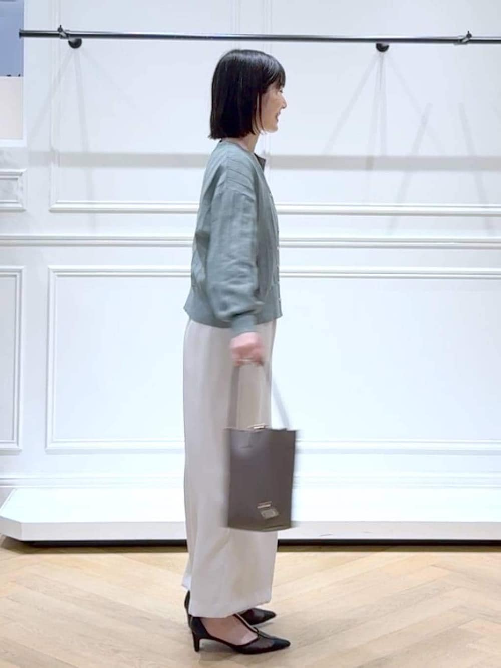 グリーン系のカーディガン/ボレロ、ブラック系のパンプス、ブラウン系のショルダーバッグを着用したレディースの春コーディネートの3枚目の写真