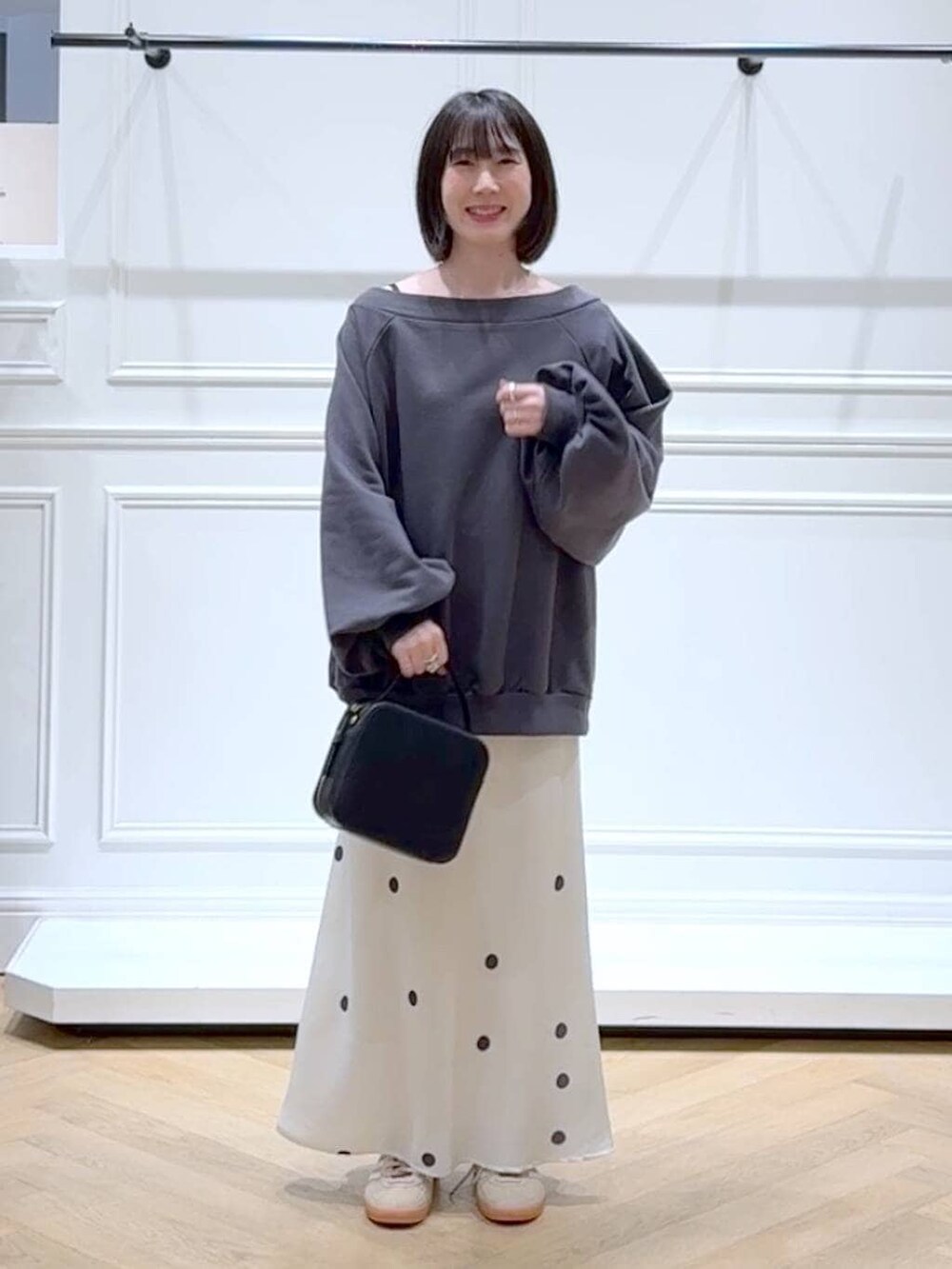 ベージュ系のスニーカー、グレー系のスウェット、ホワイト系のスカートを着用したレディースの春コーディネートの6枚目の写真