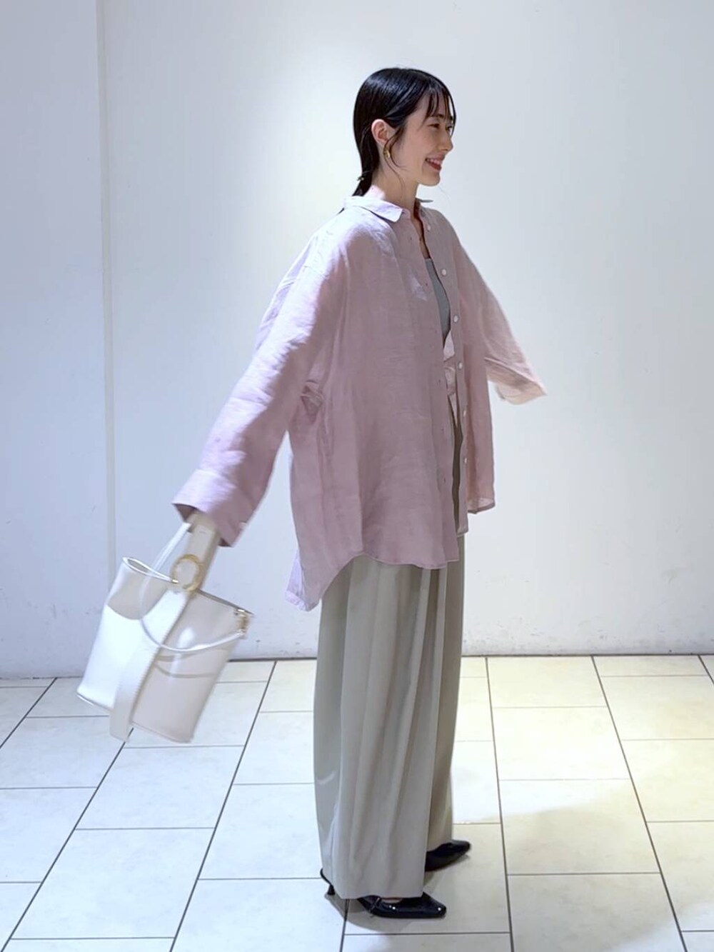 グレー系のタンクトップ、ホワイト系のショルダーバッグ、ブラック系のパンプスを着用したレディースの春コーディネートの3枚目の写真