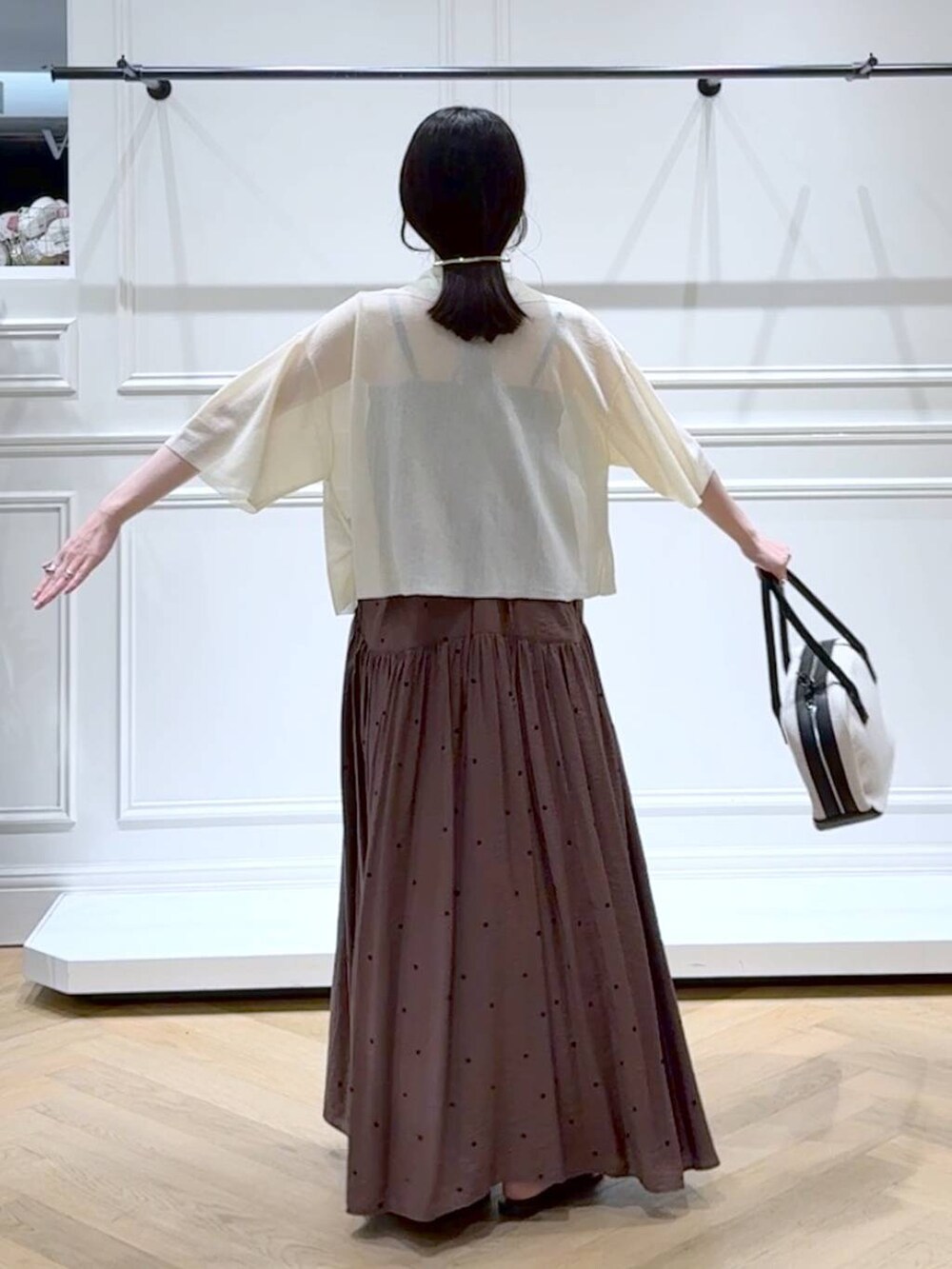 ブラック系のボストンバッグ、ブラウン系のワンピース、ブラック系のサンダルを着用したレディースの夏コーディネートの4枚目の写真