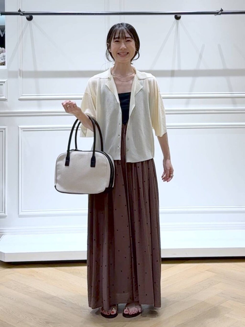 ブラック系のボストンバッグ、ブラウン系のワンピース、ブラック系のサンダルを着用したレディースの夏コーディネートの6枚目の写真