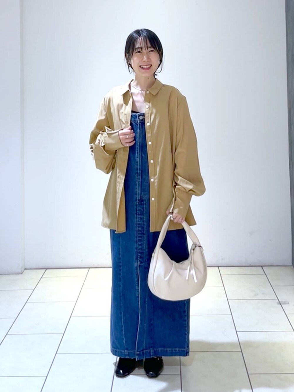 ブラウン系のシャツ/ブラウス、ブルー系のジャンパースカート、ブラック系のローファーを着用したレディースの秋コーディネートの6枚目の写真