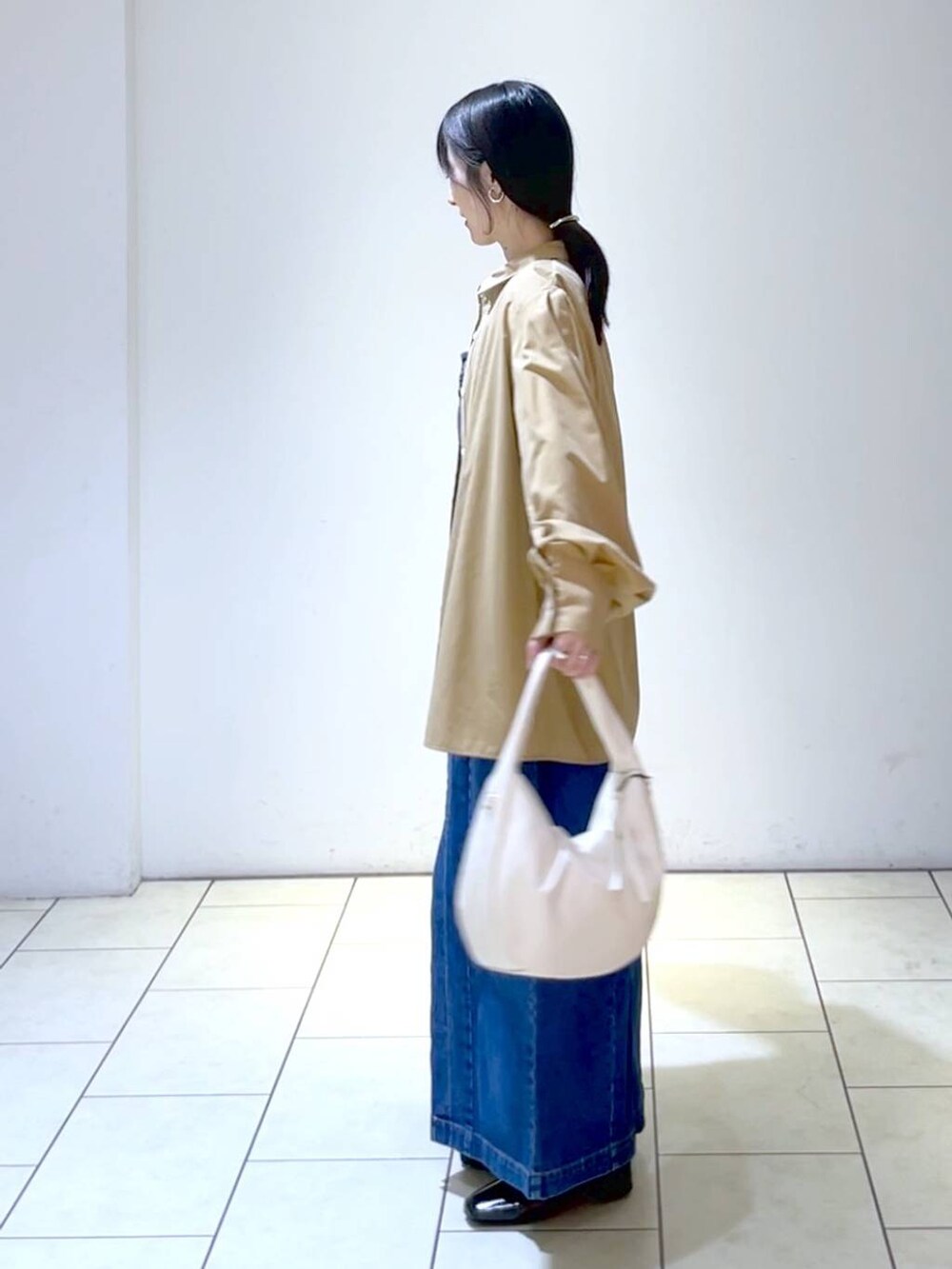 ブラウン系のシャツ/ブラウス、ブルー系のジャンパースカート、ブラック系のローファーを着用したレディースの秋コーディネートの5枚目の写真