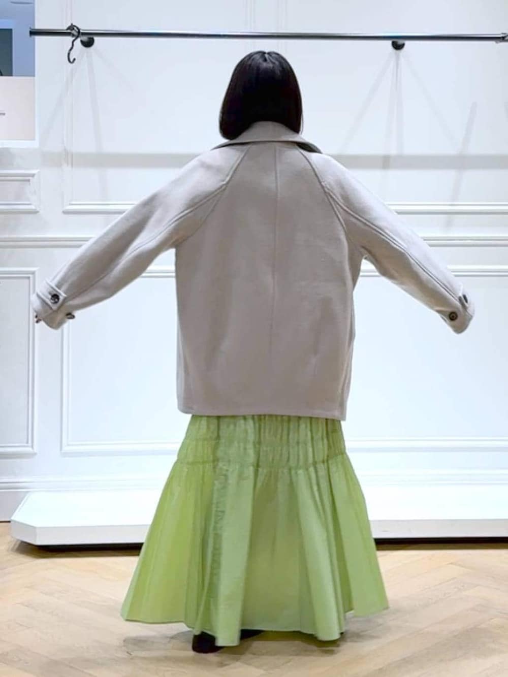 ベージュ系のピーコート、ホワイト系のニット/セーター、ブラウン系のローファーを着用したレディースの冬コーディネートの4枚目の写真