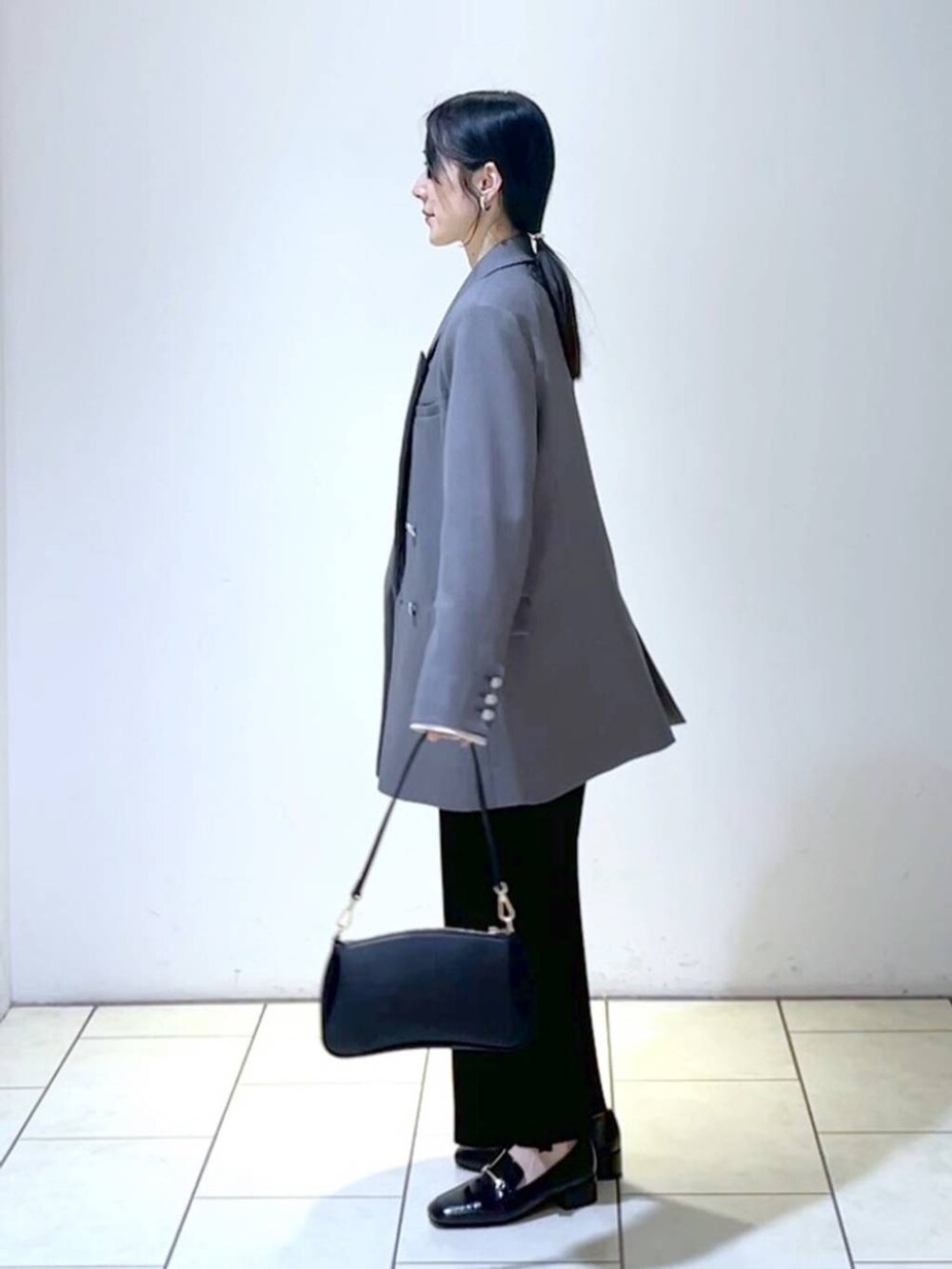 ホワイト系のシャツ/ブラウス、ブラック系のローファー、ブラック系のショルダーバッグを着用したレディースの春コーディネートの4枚目の写真