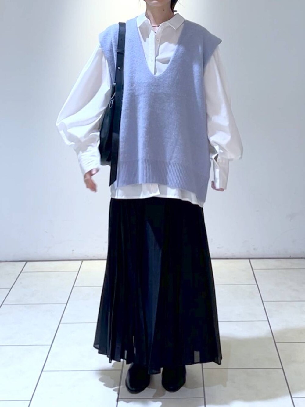 ホワイト系のシャツ/ブラウス、ブラック系のブーツ、ブラック系のスカートを着用したレディースの秋コーディネートの2枚目の写真