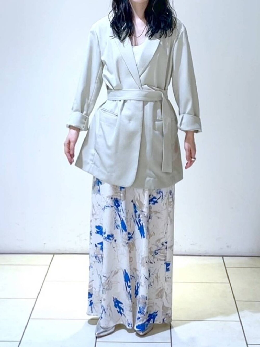 シルバー系のサンダル、ブルー系のスカート、ベージュ系のテーラードジャケットを着用したレディースの春コーディネートの2枚目の写真