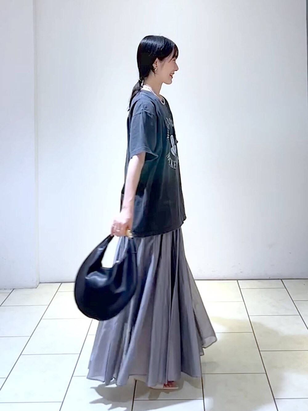 ホワイト系のサンダル、ブラック系のハンドバッグ、グレー系のスカートを着用したレディースの夏コーディネートの3枚目の写真