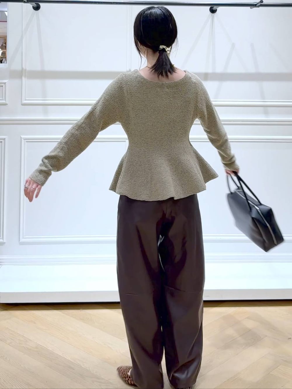 ブラウン系のその他パンツ、ブラック系のボストンバッグ、ブラウン系のパンプスを着用したレディースの秋コーディネートの4枚目の写真