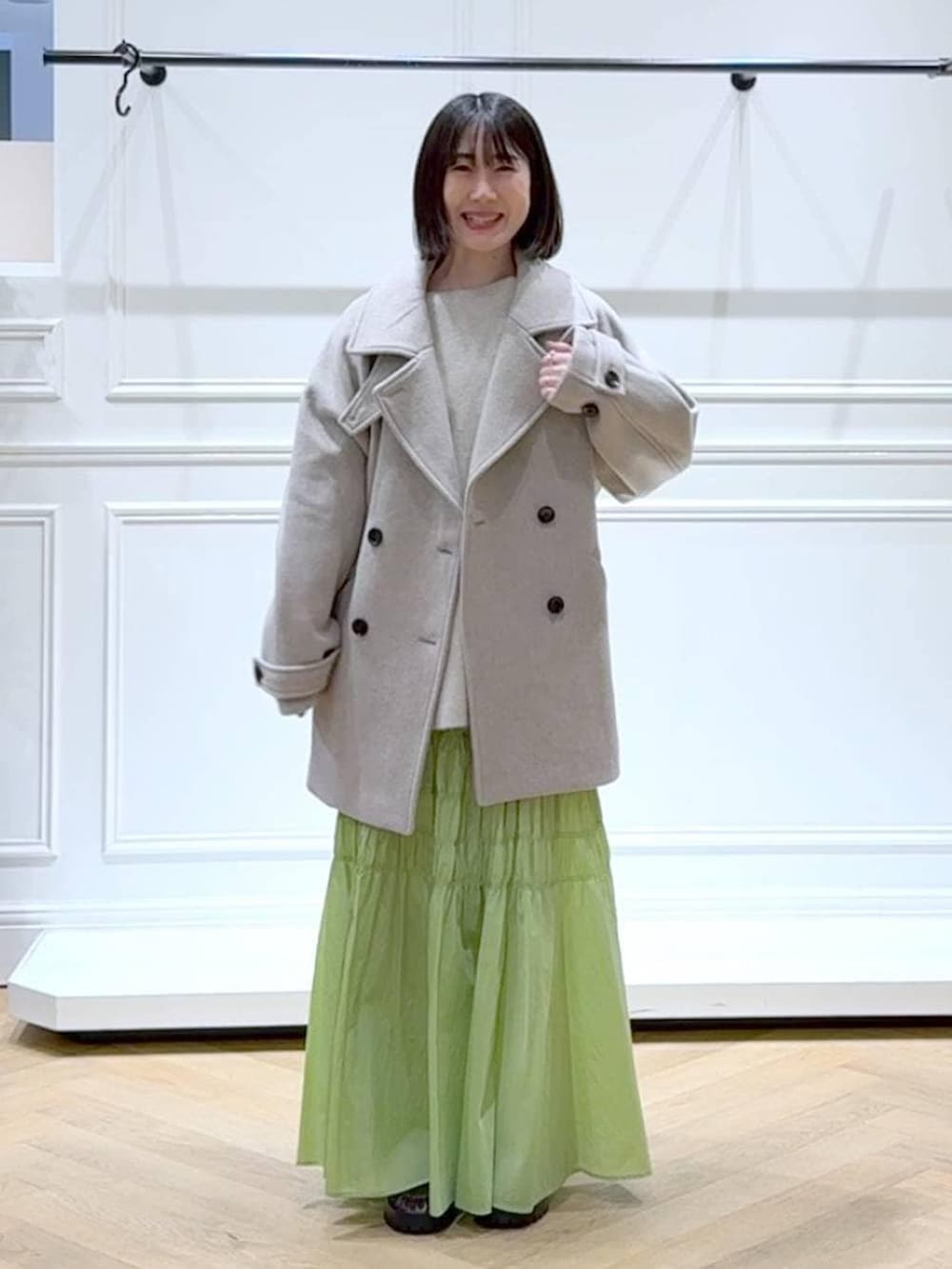 ベージュ系のピーコート、ホワイト系のニット/セーター、ブラウン系のローファーを着用したレディースの冬コーディネートの6枚目の写真