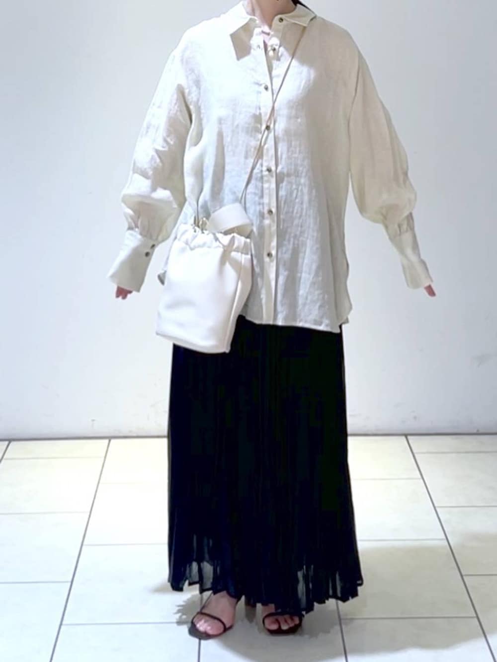 ベージュ系のシャツ/ブラウス、ブラック系のスカート、ホワイト系のショルダーバッグを着用したレディースの夏コーディネートの2枚目の写真